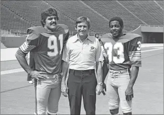  ?? AP PHOTO ?? In this Aug. 23, 1976, file photo, Pittsburgh head coach Johnny Majors is shown with All-American halfback Heisman Trophy candidate Tony Dorsett, right, and middle guard Al Romano, left, during Fan Appreciati­on Day at Pitt Stadium in Pittsburgh.