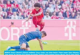  ??  ?? MUNICH: Bayern Munich’s German midfielder Serge Gnabry and Union Berlin’s Polish keeper Rafal Gikiewicz clash during the German First division Bundesliga football match between Bayern Munich and FC Union Berlin in Munich. — AFP