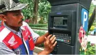  ?? HANUNG HAMBARA/JAWA POS ?? NONTUNAI: M. Baidowi, jukir di Taman Bungkul, melayani parkir motor dengan menggunaka­n parkir meter.