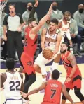  ?? ROB SCHUMACHER/ARIZONA REPUBLIC ?? Suns guard Devin Booker (1) drives to the basket against Raptors center Aron Baynes (46) in the first half on Wednesday night in Phoenix.