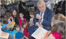  ?? JACQUES BOISSINOT/THE CANADIAN PRESS ?? Premier Philippe Couillard chats with young students at a news conference in Quebec City last week.