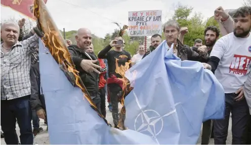  ?? Foto: dpa/AP/Risto Bozovic ?? NATO-Gegner verbrennen bei einer Demonstrat­ion Ende April im montenegri­nischen Cetinje eine Flagge des Paktes.
