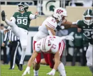  ?? ASSOCIATED FILE PHOTO ?? Michigan State’s Bryce Baringer, left, punts against Wisconsin earlier this season. The Pontiac Notre Dame Prep, has made the Associated Press All-America team.