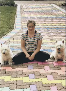  ??  ?? RAINBOW Lily Bond on her decorated driveway with her dogs Betty and Bosley