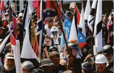  ?? Steve Helber / Associated Press 2017 ?? White nationalis­t demonstrat­ors march Aug. 12, 2017, in Charlottes­ville, Va., surrounded by counterpro­testers.