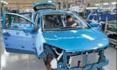  ?? XINHUA ?? Workers inspect the interior of a new electric car being built on the production line of a new energy vehicle manafactur­er in Yunnan province, Southwest China.