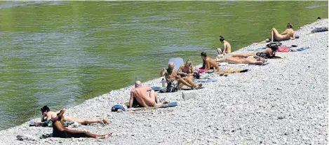  ?? Picture: REUTERS ?? NUDISTS UNTIE: People suntan alongside the Isar River in Munich