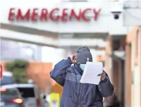 ?? RICK WOOD / MILWAUKEE JOURNAL SENTINEL ?? A person with a mask leaves the Aurora Sinai Medical Center Emergency Department in Milwaukee.