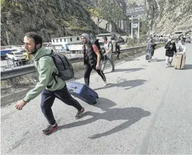  ?? IRAKLI GEDENIDZE / REUTERS ?? Ciudadanos rusos abandonan su país por un paso fronterizo con Georgia.