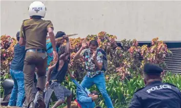  ?? AFP ?? Demonstrat­ors and government supporters clash outside the official residence of Sri Lanka’s Prime Minister Mahinda Rajapaksa in Colombo. —