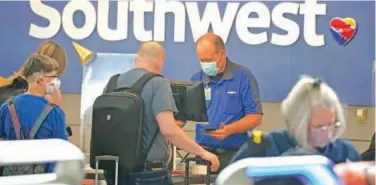  ?? File/associated Press ?? ↑
Southwest Airlines ticketing agent helps a traveller at the check-in counter at Denver Internatio­nal Airport.