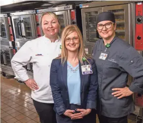  ?? JOHN MANIACI ?? Executive chef Ellen Ritter (from left), director of culinary and clinical nutrition services Megan Waltz and sous chef Lisa Boté stand in the kitchen of University Hospital.
