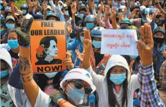  ?? AFP via Getty Images ?? Protesters raise threefinge­r salutes — a symbol of defiance — during a rally against the coup in the capital of Naypyitaw. The military junta ousted elected leader Aung San Suu Kyi on Feb 1.