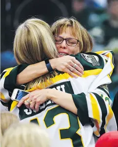  ??  ?? Mourners comfort each other during a vigil Sunday in Humboldt, Sask. Mayor Rob Muench said people have been sending poems, songs and messages of deep sorrow.