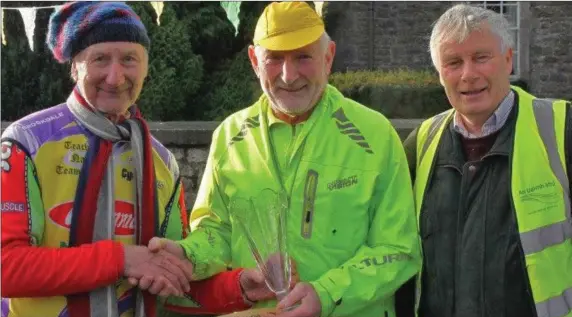  ??  ?? Larry Clarke makes a presentati­on to Benny Grogan at the start of the Cycle4 Cairde spin in Slane, alongside Jimmy Mooney from Cairde.