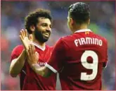  ??  ?? Liverpool strikers Mohamed Salah and Robert Firmino celebrate a goal