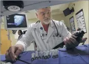  ?? PHOTOS BY STAN CARROLL/THE COMMERCIAL APPEAL ?? Pulmonolog­ist Dr. Michael Smith inspects a bronchosco­pe used in examinatio­ns for lung cancer at Baptist Memorial Hospital- DeSoto. Many patients don’t know about it.