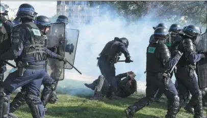  ?? ALAIN JOCARD / AFP ?? A protester cowers as a police officer stands over him in clashes that erupted during the May Day rally in Paris on Sunday.