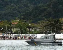  ?? Gustavo Porto/Futura Press/Folhapress ?? Moradores de Guarujá com mercadoria que caiu do navio