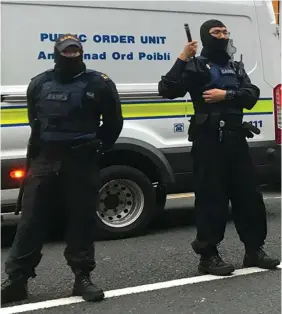  ??  ?? On standby: Masked gardaí from the public order unit were on the scene and watched as the civilians wearing balaclavas broke into the house on North Frederick Street using an angle-grinder