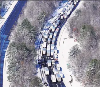  ?? Steve Helber / Associated Press ?? Drivers wait for the traffic to be cleared as cars and trucks are stranded on sections of Interstate 95 on Tuesday in Carmel Church, Va. Close to 48 miles of the Interstate was closed due to ice and snow.