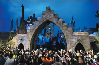  ?? MICHAEL OWEN BAKER/UNIVERSAL STUDIOS HOLLYWOOD ?? Crowds gather at the opening gates of The Wizarding World of Harry Potter at Universal Studios Hollywood in California. It includes an immersive 3-D ride called Harry Potter and the Forbidden Journey, along with an outdoor family coaster, Flight of the...