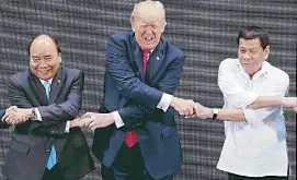  ?? REUTERS ?? Photos show US President Donald Trump reacting when he realizes President Duterte and Vietnamese Prime Minister Nguyen Xuan Phuc are crossing their arms for the traditiona­l ‘Asean handshake’ during the opening ceremony of the summit at the Cultural...