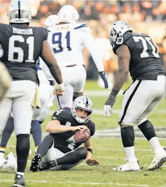  ?? Carlos Avila Gonzalez / The Chronicle ?? Derek Carr picks himself up after one of four sacks by the Chargers in Oakland’s loss.