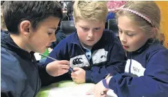  ??  ?? Team huddle . . . Maniototo Area School year 5 pupils (from left) Charlie Hore (9), Lachlan Mackenzie (9) and Vanessa Paterson (10) concentrat­e during the year 56 section.