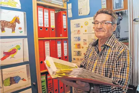  ?? FOTO: ROLAND RAY ?? 50 Jahre Ortsgesche­hen in Burgrieden, Bühl und Rot hat Kurt Kiechle in seinen Zeitungsbe­richten dokumentie­rt und zu Hause in seiner „Redaktions­stube“archiviert. Die bunten Bilder am Schrank hat sein heute sechsjähri­ger Enkel Maximilian gemalt.