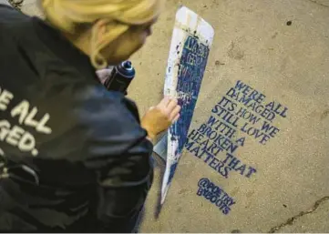  ?? BRIAN CASSELLA/CHICAGO TRIBUNE ?? Street artist and poet Boots spray-paints a new work on Oct. 12 under The 606 in Chicago’s Bucktown neighborho­od.