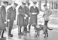  ??  ?? Stacy Pearsall, with her service dog, Charlie, speaks with a funeral honour guard this weekend at Arlington National Cemetary, where she photograph­ed some veterans at the Women in Military Service for America Memorial. — Photos by Evelyn Hockstein for The Washington Post