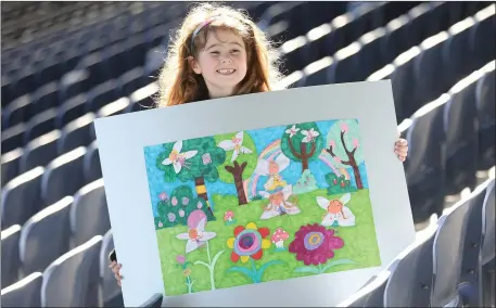  ??  ?? Kelly from Arklow with her artwork, which won the seven years and under category in the All-Island Credit Union Art Competitio­n.