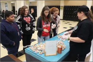  ?? The Sentinel-Record/Richard Rasmussen ?? TASTE TESTERS: Hot Springs World Class High School students, from left, Micah Ellis, Zoee Burns, Tillie Reagler and Liliana Boekhout get samples from Tammy Green with the food service company Chartwells Thursday as part of a Student Choice program, which allows students to taste new cafeteria menu items and vote on their favorites. The top votes will be added to the menu.