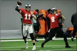  ?? The Associated Press ?? PRESEASON: Eagles quarterbac­ks Carson Wentz (11) and Nick Foles (9) throw passes Monday during the team’s training camp in Philadelph­ia.