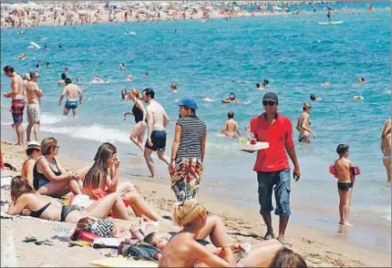  ?? GEMMA MIRALDA ?? La venta de mojitos de dudosa procedenci­a es habitual en primera línea de las playas de Barcelona