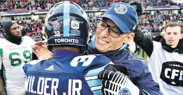  ?? FRANK GUNN/THE CANADIAN PRESS ?? The Argos’ James Wilder Jr. is hugged by head coach Marc Trestman after Toronto’s win over the Saskatchew­an Roughrider­s in Sunday’s East Division final.