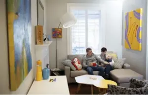  ?? COLE BURSTON FOR THE TORONTO STAR ?? NOW: The Diakuns, with baby son Adrian, relax in their compact and comfortabl­e living room, surrounded by artworks that reflect their love of bold colours.