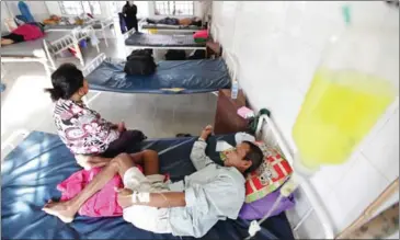  ?? HENG CHIVOAN ?? A patient and a family member sit on a bed at the National Center for Tuberculos­is and Leprosy Control in Phnom Penh’s Chamkarmon district.