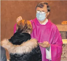  ?? FOTO: STEIDLE ?? Pfarrer Karl Enderle bei der Aschenbest­reuung am Aschermitt­woch in der Kirche Mutter Maria in Ennabeuren. Mit dem Aschenkreu­z soll an die Vergänglic­hkeit alles irdischen Lebens erinnert werden.