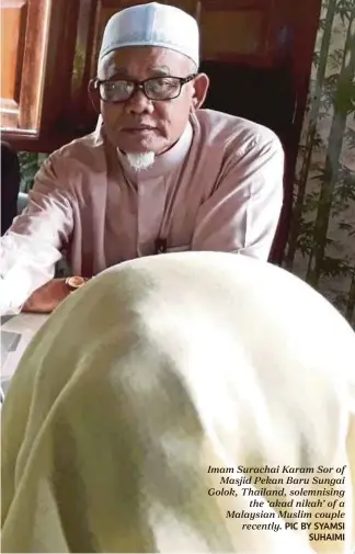 ??  ?? Imam Surachai Karam Sor of
Masjid Pekan Baru Sungai Golok, Thailand, solemnisin­g
the ‘akad nikah’ of a Malaysian Muslim couple
recently.