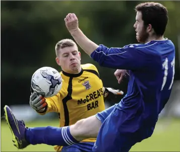  ??  ?? Carnew goalkeeper Paddy Adair reaches the ball ahead of Aughrim’s Adam Stokley.