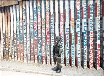  ?? Foto Ap ?? Un integrante de la recién formada Guardia Nacional vigila desde Tijuana, Baja California, la frontera entre Estados Unidos y México, justo en la sección del muro donde están inscritos los nombres de militares veteranos deportados de Estados Unidos.