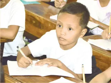  ?? (SUN.STAR FOTO/ALAN TANGCAWAN & FOTO FROM JOYCE TORREFRANC­A'S FACEBOOK ACCOUNT) ?? HE'D LOVE SOME ELECTRICIT­Y AND A DRAWING BOOK.Grade 3 pupil Daniel E.Cabrera (above) attends the Subangdaku Elementary School during the day, then studies by the light of a McDonald's drive-through outlet at night. A photo of him studying, posted in the Facebook account of Joyce Torrefranc­a, appears to have moved hundreds online.