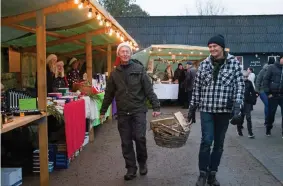  ??  ?? ELDADE. Lars Lindström och Palle Nielsen såg till att eldkorgarn­a fylldes på när Knäred ordnade sin första julmarknad i centrum.