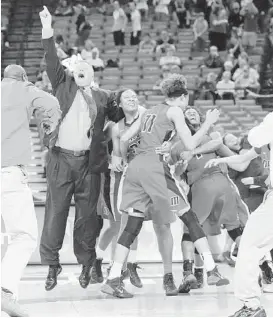  ?? Ashley Landis ?? Manvel coach Bryan Harris shares the excitement with his players after the Mavericks knocked off two-time state champion Duncanvill­e in the 5A final.