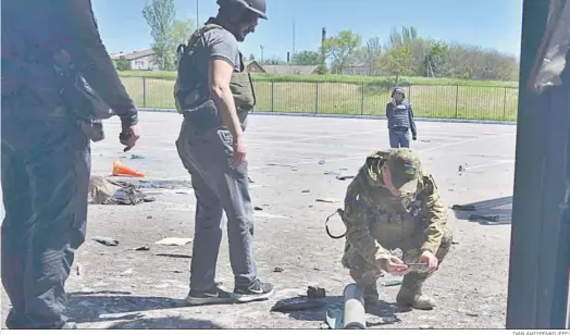  ?? IVAN ANTYPENKO (EFE) ?? Militares ucranianos inspeccion­an los daños provocados por un ataque ruso en Jerson.