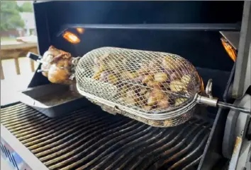  ?? Courtesy of Napoleon Grills ?? A rotisserie basket can be used for roasting vegetables, chicken wings or even french fries.