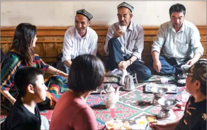  ?? WANG FEI / XINHUA ?? Tourists talk to patrons at a centuries-old teahouse in the Old Town.