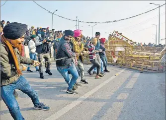  ?? SAKIB ALI/HT PHOTO ?? Demonstrat­ors removing police barricades while heading into Delhi. As per the designated route, tractors were to move to road number 56 from the Ghazipur roundabout but a majority of tractors allegedly moved on to the expressway lanes.